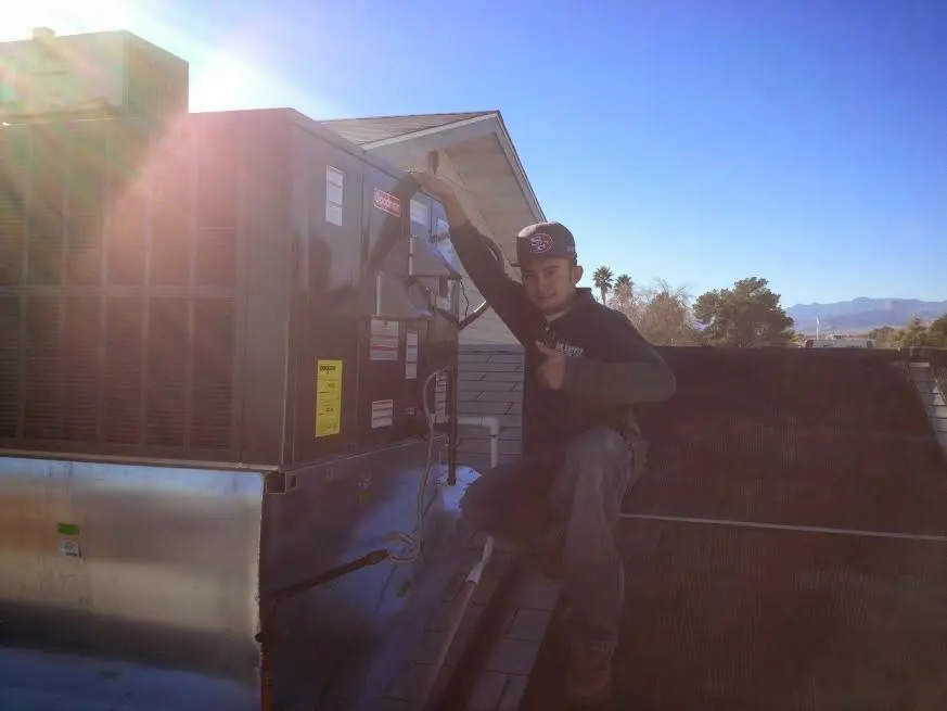 HVAC technician performing Heat Pump Repair on a rooftop unit in Audubon